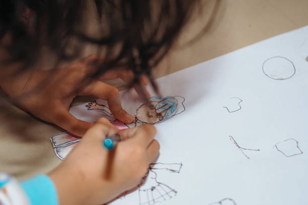close up of a child's hand drawing on paper