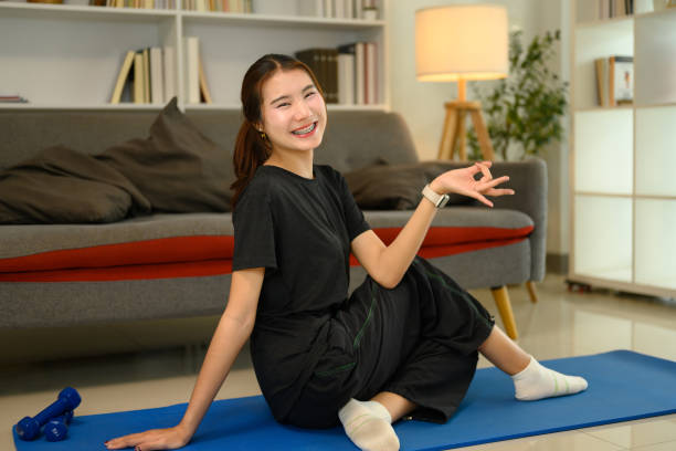 istock Smiling young woman practicing yoga at home. Balanced and active lifestyle concept 2190640825