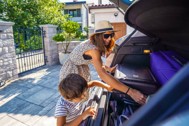 istock Mother and son loading luggage into car trunk for summer vacation 2190640984