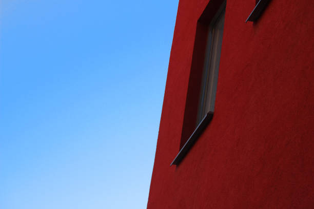 A red building with a clear blue sky beside
