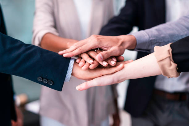 istock Team Members Joining Hands in a Symbolic Gesture of Collaboration and Unity at a Work Environment 2190643747