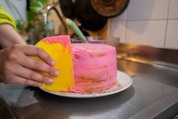Close-up of a confectioner decorating a cake in the kitchen