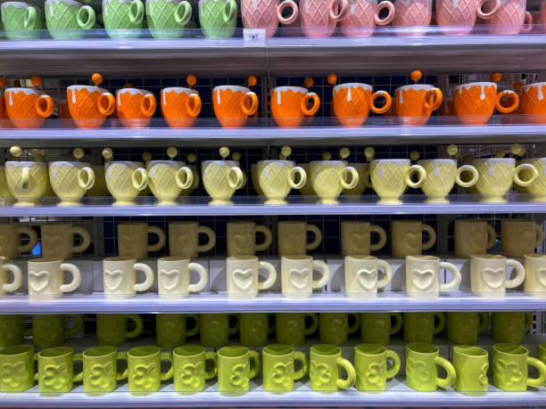 istock A neatly organized shelf displaying colorful ceramic mugs with unique textures and vibrant hues of green, orange, and yellow. 2190650566
