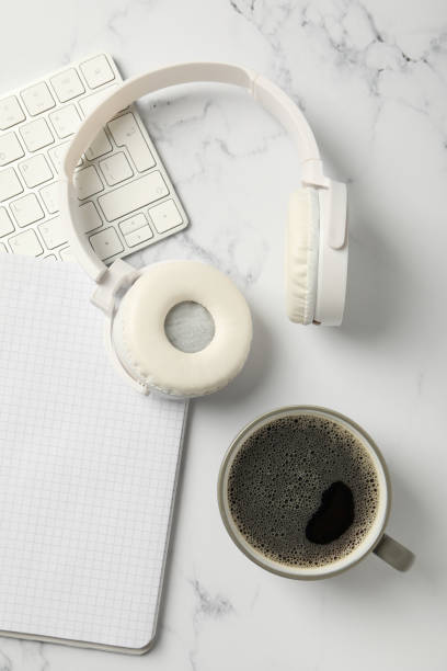 istock A cup of coffee with headphones and a keyboard on a white background 2190651269