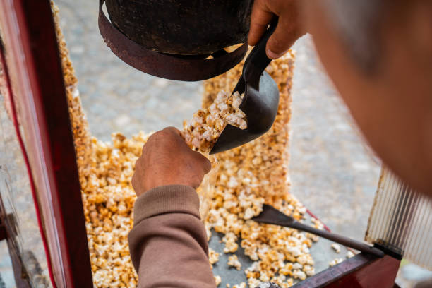 Close-up of a salesman preparing popcorn in the popcorn machine