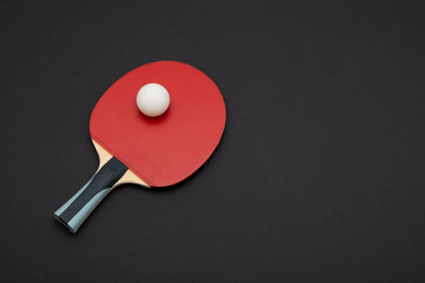 istock Professional Red Table Tennis Paddle with White Ball on Dark Background 2190653665
