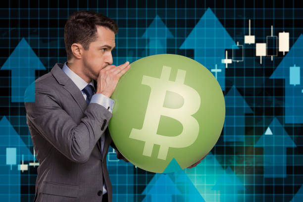 istock Businessman inflating Bitcoin bubble with rising market 2190654073