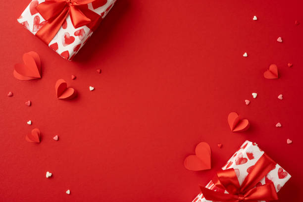 istock Beautiful Valentine's Day scene with gift boxes and heart decorations on a red backdrop. Perfect for celebrating love and expressing romantic feelings with thoughtful gifts 2190654235