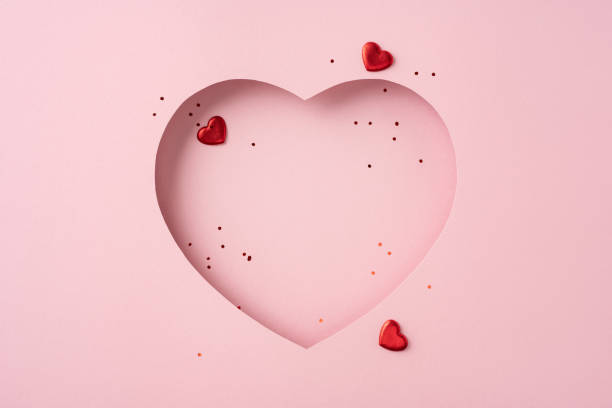 istock A heart shaped cutout design with scattered confetti and small hearts on a pink background, symbolizing love and celebration 2190654285