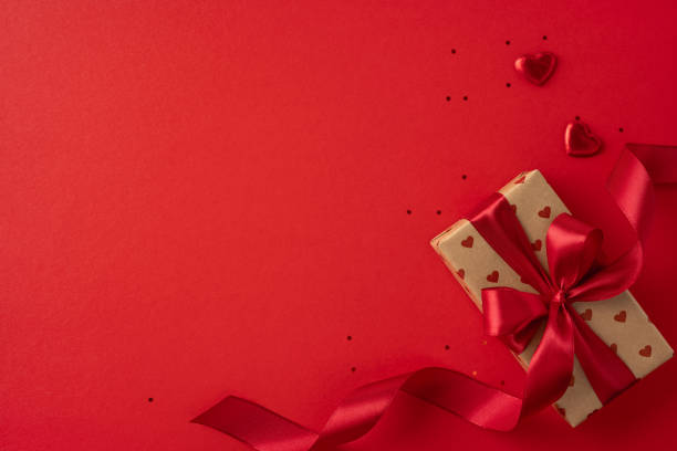 istock A beautifully wrapped gift with a red ribbon and heart decorations on a vibrant red background, perfect for Valentine's Day. The scene evokes love, romance, and celebration 2190654330