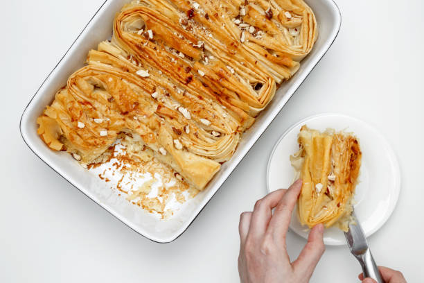 istock Finished Crinkle Cake made from phyllo dough is cut with a knife 2190655273