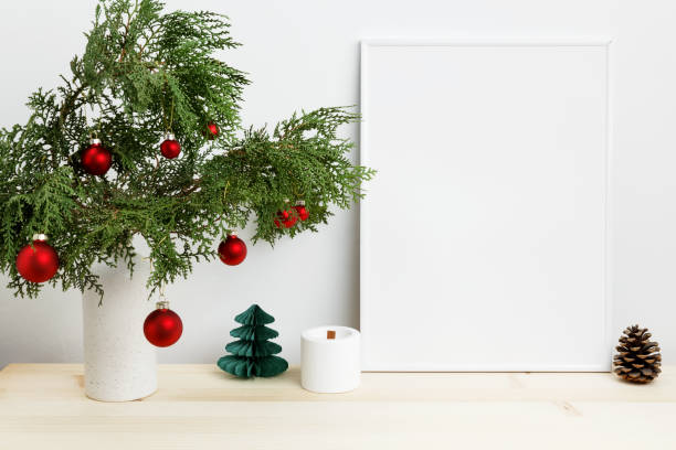 istock White frame for mockup with thuja branches in a vase decorated with Christmas ornaments 2190655497