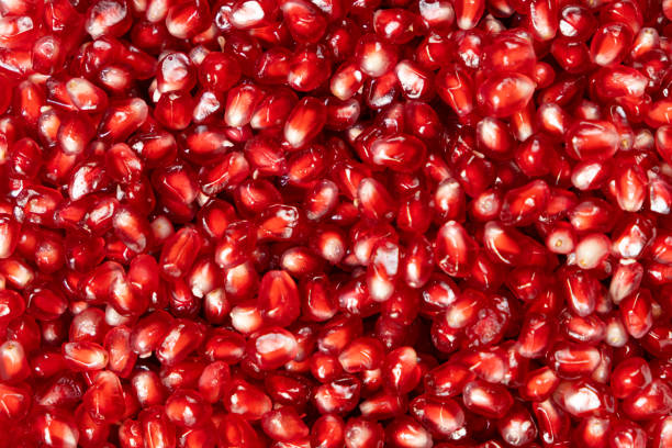 istock Ripe red pomegranate seeds close-up top view 2190655659