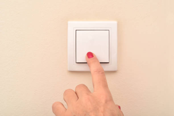 istock Hand of a woman turning light off or on at the switch 2190656044