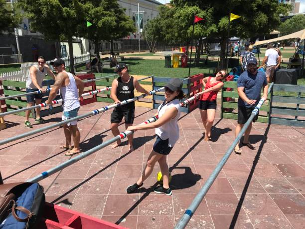Auckland, New Zealand - January 14, 2018: Group of friends enjoying a sunny day in Auckland, New Zealand, while playing soccer, an exciting game with long sticks, filled with laughter and vibrant energy in the lively urban setting