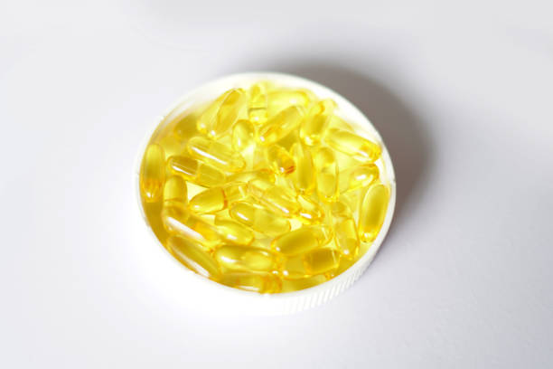 istock cod liver oil capsules, fish capsules, cod liver oil capsules in bottle lid. white background 2190656401