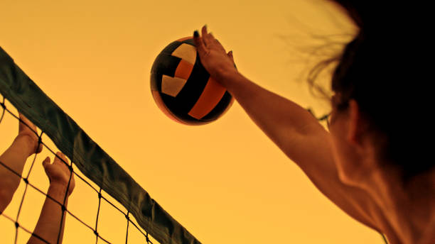 istock Group Enjoying Beach Volleyball Game at Sunset 2190656655