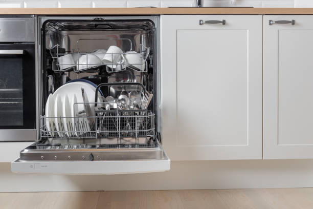 istock Built-in dishwasher full of clean dishes with its door open, white utensil. Modern technologies in the home kitchen with minimalistic cabinetry. Simplifying daily housework. 2190658340