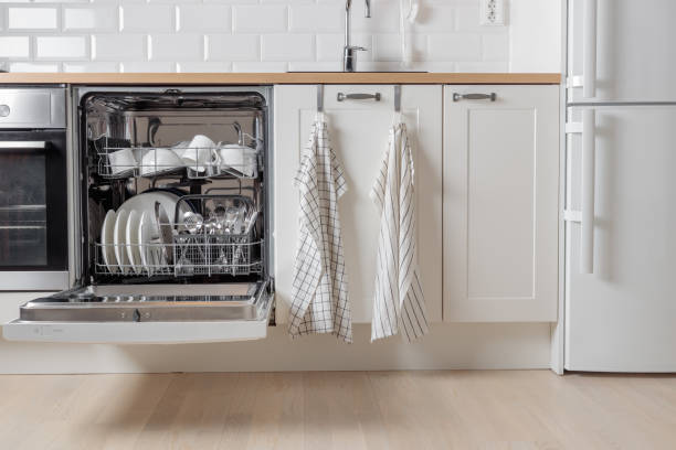 istock Built-in dishwasher full of clean dishes with its door open, white utensil. Modern technologies in the home kitchen with minimalistic cabinetry. Simplifying daily housework. 2190658426