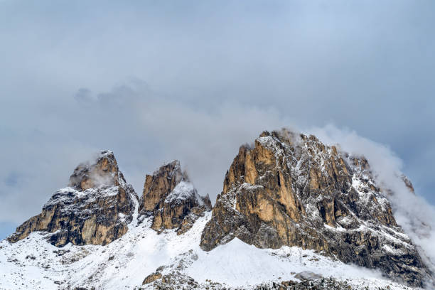 The impressive Langkofel or Sassolungo mountain in the Italian Dolomites covered in snow during a springtime morning in the Italian Alps.