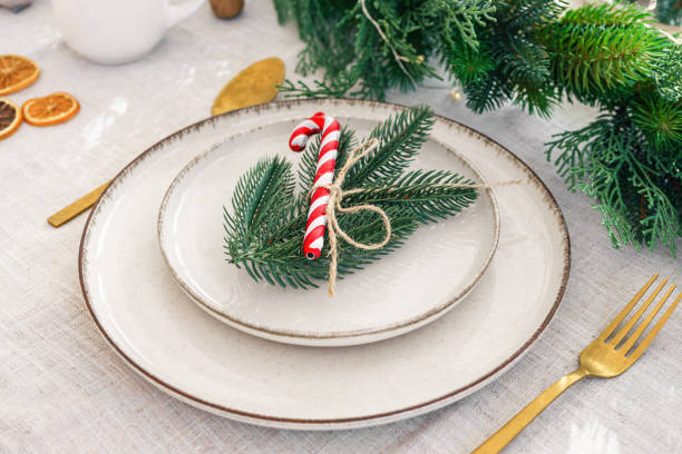 istock Festive dining table setting with greenery and seasonal Christmas decorations for holiday meal 2190659226