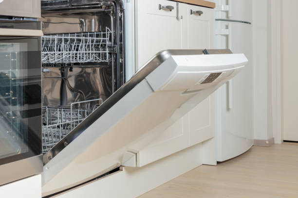 istock Built-in empty dishwasher with its door open. Modern technologies in the home kitchen with minimalistic white cabinetry. Simplifying daily housework. 2190660400