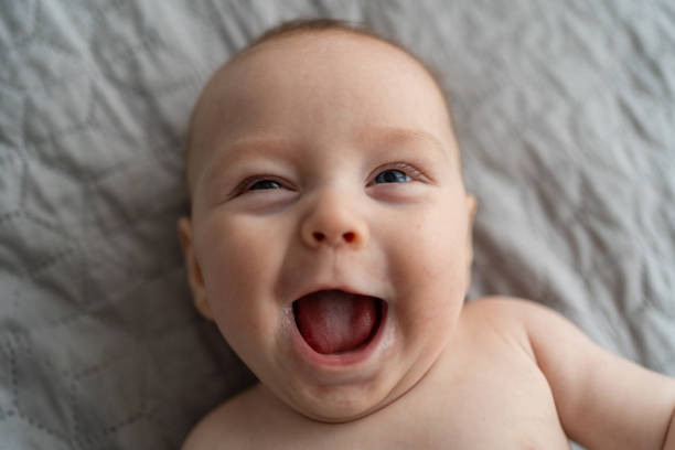 istock Baby boy having fun making a face while lying on bed at home 2190663640