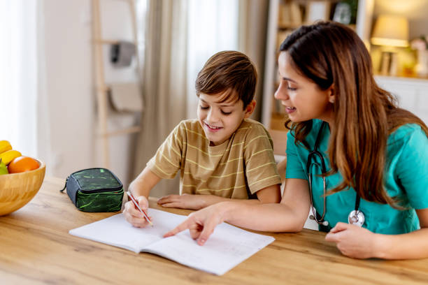 istock Caring nurse supporting pediatric patient during homework session, providing educational assistance with compassionate mentorship 2190666448