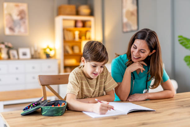 istock Caring female pediatrician helping young patient with schoolwork, creating nurturing moment with warm interaction and encouraging smile 2190666461
