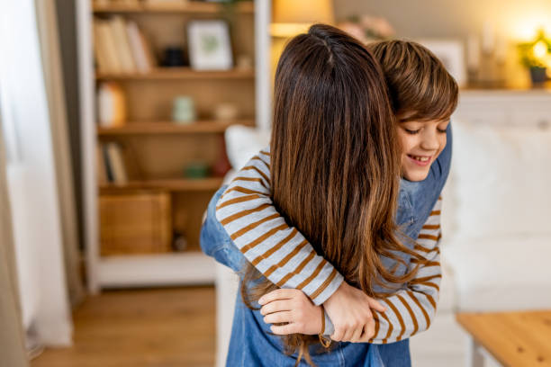 istock Loving siblings embracing, sharing warm family connection inside comfortable living space 2190666676