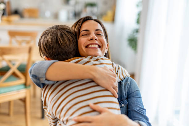 istock Mother hugging son tightly, eyes closed, sharing loving moment in warm kitchen, affection and happiness evident 2190666875