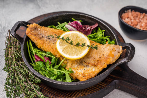 istock Fried Haddock fish fillet in a pan. grey background. top view 2190667115