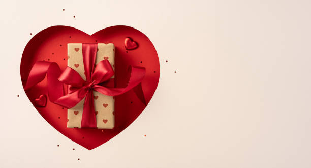 istock Heart shaped cutout featuring a beautifully wrapped gift with a red ribbon. Ideal for Valentine's Day themes, love, romance, and special occasions. Perfect for expressing affection visually 2190668165