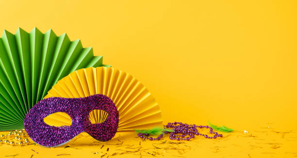 istock Mardi Gras side view celebration concept featuring a glitter mask, vibrant paper fans, and festive beads 2190668202