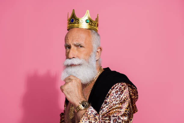 istock Portrait of eccentric ancient king gold crown leopard coat hand touch beard empty space isolated on pink color background 2190670179