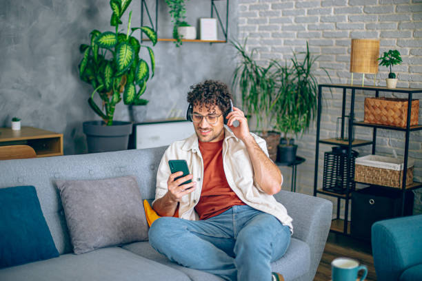 Man relaxing at home with music and smart phone