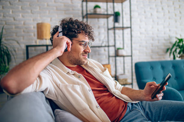 istock Man relaxing at home with music and smart phone 2190671518
