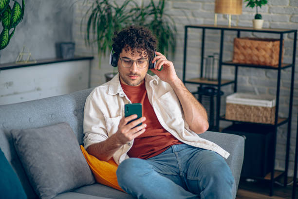 istock Man relaxing at home with music and smart phone 2190671666