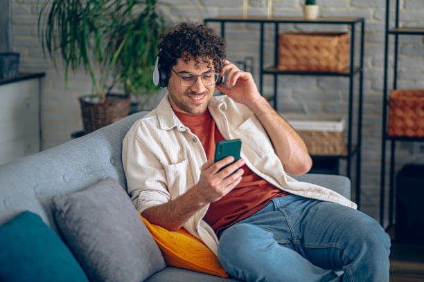 istock Man relaxing at home with music and smart phone 2190671689