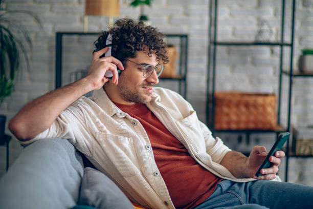 istock Man relaxing at home with music and smart phone 2190671825