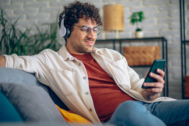 istock Man relaxing at home with music and smart phone 2190671888