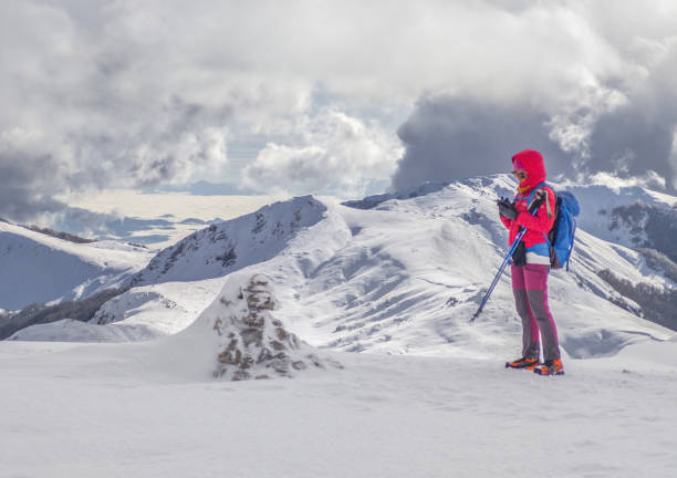 Campocatino and Mount Pozzotello, Italy - 15 December 2024 - The snow capped mountains in the province of Frosinone, Lazio region, in Ernici mounts, famous for ski site station. Here a view with girl alpinist.