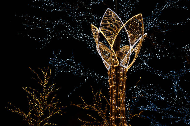 Flower-shaped christmas lights shining brightly against a backdrop of twinkling tree lights, creating a festive atmosphere