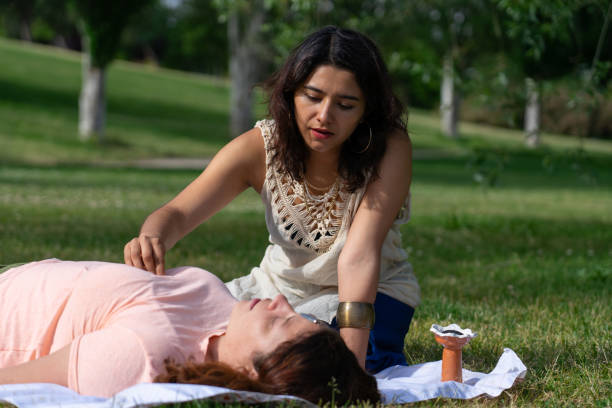 istock Therapist performing reiki session on patient lying in park 2190676988