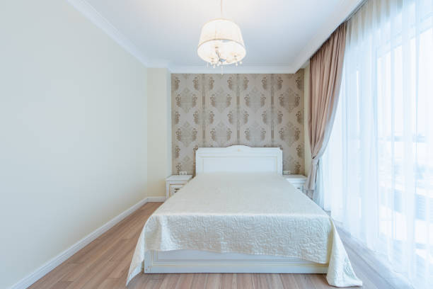 A tastefully furnished bedroom featuring classic decor, wooden flooring, and windowed curtains allowing natural light to illuminate the space. Elegant Home Bedroom Interior