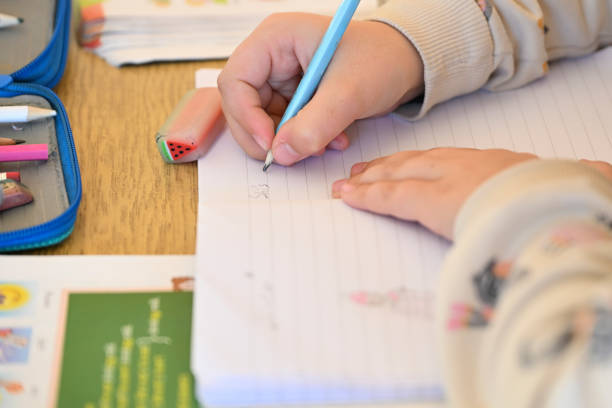 istock Hand of primary school pupil writing and drawing with pencil 2190681502