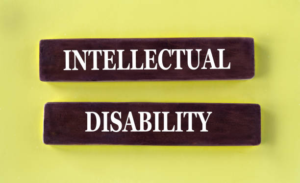 istock INTELLECTUAL DISABILITY - words on brown wooden blocks on a yellow background 2190682078