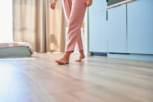 istock Barefoot female legs on comfortable heated warm tiles at home. Modern floor heating system in house 2190684356