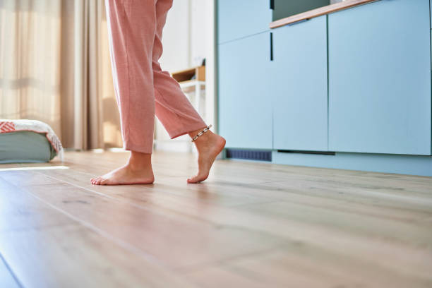 istock Barefoot female legs on comfortable heated warm tiles at home. Modern floor heating system in house 2190684381