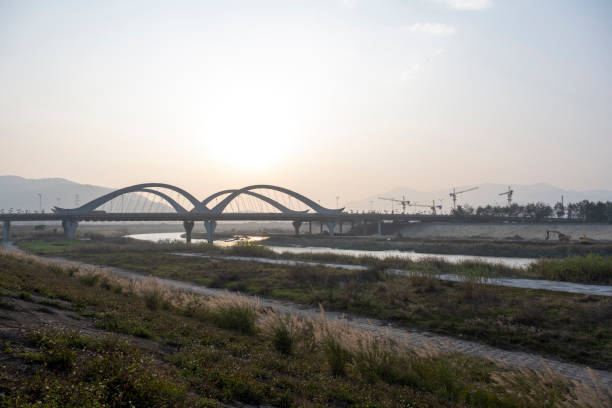 The small path by the embankment, the distant bridge, and the building under construction